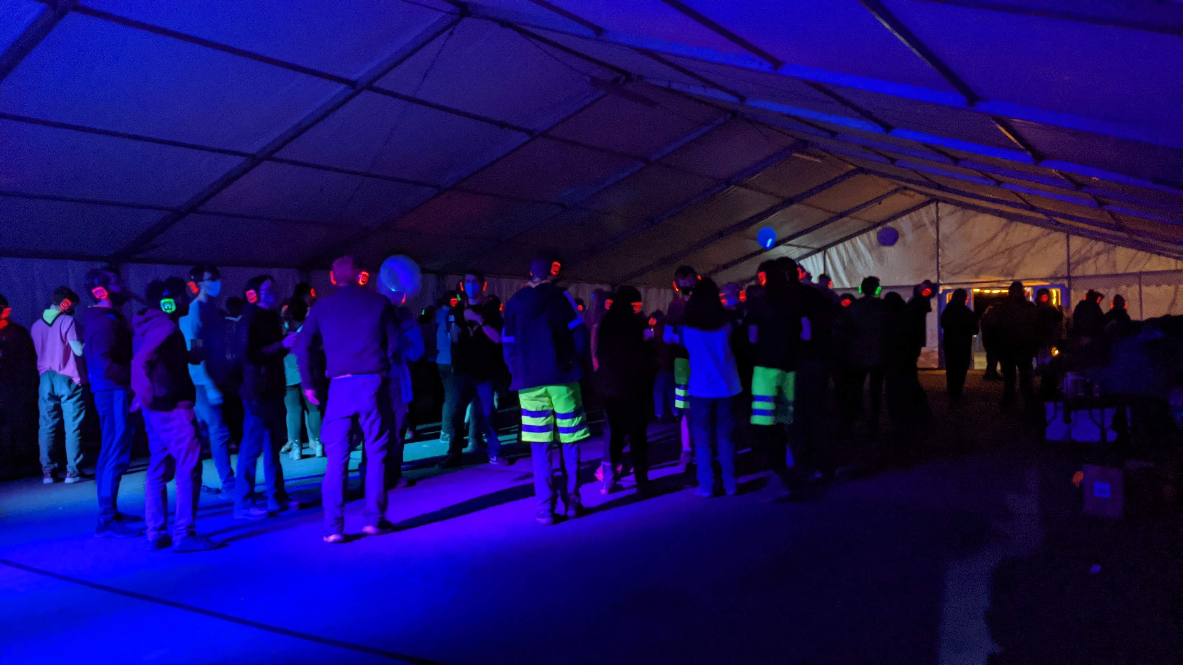 Wide shot of the marquee with people dancing during the silent disco, with Southampton's hi-vis shorts being very visible